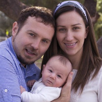 parents posing with infant