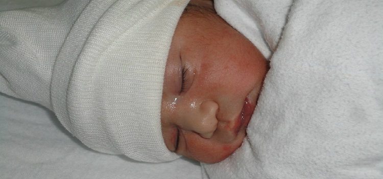 infant wrapped in hospital blanket