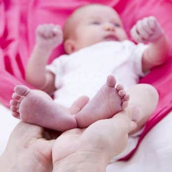 parent holding infant's feet